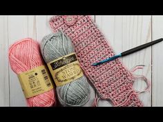 two balls of yarn next to a crochet bag and knitting needles on a white wooden surface