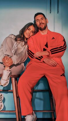 a man and woman sitting on top of a stool