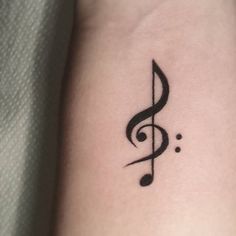 a small musical note tattoo on the wrist