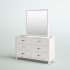 a white dresser with a mirror on top and drawers below it, against a light blue background