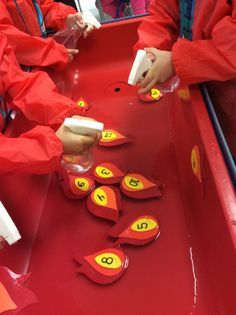 children playing with numbers and shapes on a red table