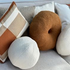 three pillows are sitting on a couch with one pillow and the other two donuts