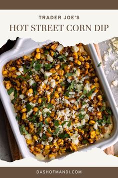 a casserole dish with corn and cheese in it on a wooden cutting board