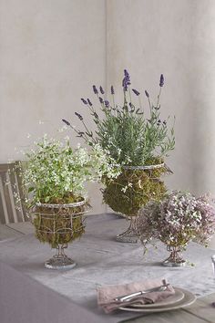 three vases filled with flowers sitting on top of a table