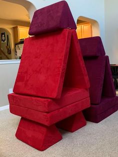 two large red and purple chairs sitting on top of a carpeted floor next to each other