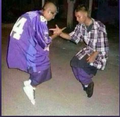 two men dressed in purple dancing on the street