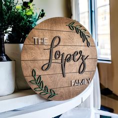 a wooden sign sitting on top of a white shelf next to a potted plant