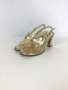 "Highly recommend getting a good pedicure for these sassy vintage 1960s gold lame leather peep toe high heels Made of gold lame leather clear plastic toebox that is highlighted with a gold strap.  Gold instep The heel of the shoe is also covered in gold-colored leather Adjustable slingback strap for a secure fit, gold toned metal buckle  Soles of the shoes are made of leather Open-toe peep-toe style Measurements: Marked size 5M US 5 US/ 34.5 EU/ 21 Asia Insole: 8 5/8\" Ball: 2.75\"  Heel height: Gold Slingback Sandals With Round Toe For Party, Gold Open Toe Slingback Sandals For Party, Gold Pointed Toe Slingback Sandals For Party, Gold Slingback Sandals For Party, Gold Slingback Sandals For Party With Open Heel, Glamorous Gold Open Toe Slingback Pumps, Gold High Heel Slingback Sandals For Evening, Gold Slingback Sandals With Round Toe For Formal Occasions, Gold Closed Toe Slingback Sandals For Evening