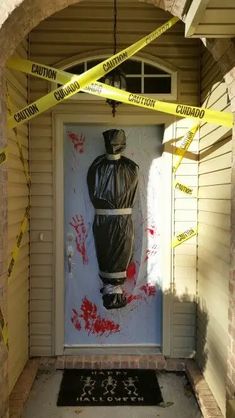 an entrance to a building with yellow caution tape around it and a painting on the door