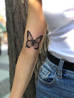 a woman's arm with a butterfly tattoo on the left side of her arm