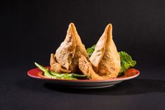 three fried food items on a plate with garnishes and green leaves in the middle