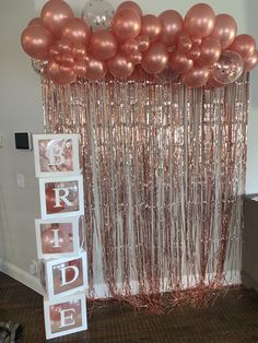 some pink balloons are hanging from the ceiling and there is a sign that says bride