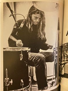 an open book with black and white photos of a man playing drums