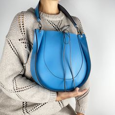 This bag, like all the others, uses our original ideas and handicrafts  Our quality is always higher than the price, see for yourself. One of the variations of the popular saddle bag model for women. Made of smooth high quality Italian Mastrotto leather in an organic combination of blue and grey color. Eco leather lining (inside). Luxurious quality. Stylish and roomy women's bag of the original form. All-weather, applicable for different images. Luxury quality. Large internal compartment. Quality fittings in nickel color. Leather strap 60 cm for carrying in the hand, on the shoulder or in the crook of the elbow. This model can be made of leather of different colors. Combines perfectly with casual style. Modern appearance. Wonderful gift for girlfriend, sister, mother or yourself. 🎁 🔺Type Tote Leather Bag, Handbag Luxury, Large Leather Bag, Blue Tote, Zipper Bag, Saddle Bag, Exclusive Bag, Handbag Shopping, Bag Fashion