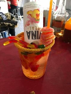 a tall glass filled with ice cream and fruit on top of a red table cloth