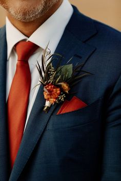 a man in a suit and tie with a boutonniere on his lapel