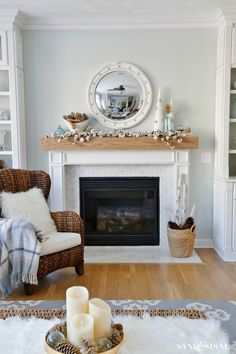 a living room filled with furniture and a fire place in front of a mirror on the wall