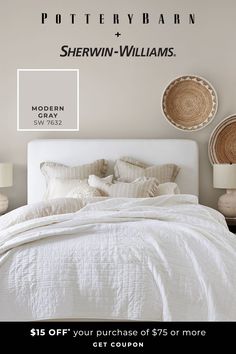 a white bed with pillows and blankets in front of a wall that says pottery barn