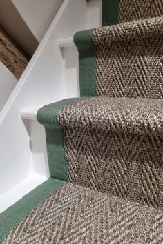 a carpeted staircase with green and beige runnering