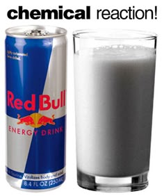 a can of red bull energy drink next to a glass full of milk and ice