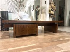 a coffee table sitting on top of a hard wood floor next to a vase filled with flowers