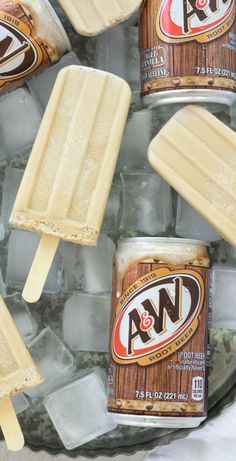 four ice cream popsicles sitting on top of an ice tray filled with ice cubes