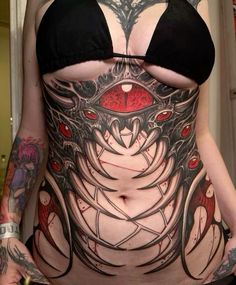 a woman with tattoos on her stomach and chest