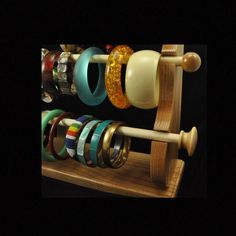 several bracelets are hanging on a wooden rack with rings attached to the handles and sides