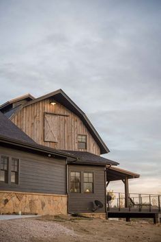 a large brown barn sitting on top of a dirt field