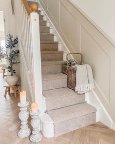 the stairs in this house have been decorated with candles and blankets on them, along with two wicker baskets