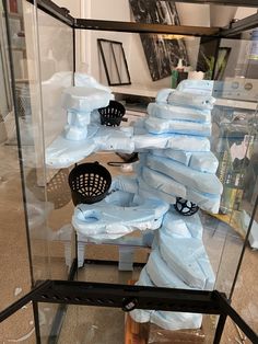 a glass case filled with lots of blue plastic bags on top of a wooden table