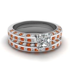 an orange and white diamond ring set on top of each other with two bands around the band