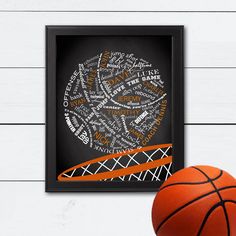 a basketball sitting on top of a wooden floor next to a framed wall mounted poster