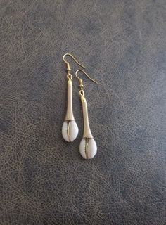 Cowrie shell and gold wire dangle earrings Gold Shell-shaped Brass Earrings, Gold Brass Shell-shaped Earrings, Gold Brass Shell Earrings, Gold Shell-shaped Metal Earrings, Gold Beaded Earrings For Beach, Gold Dangle Teardrop Earrings For Beach, Gold Teardrop Earrings For The Beach, Bohemian Gold Shell-shaped Earrings, White Brass Earrings For Beach