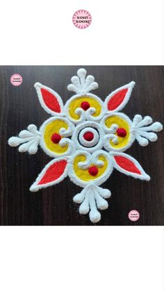 an embroidered snowflake with red, yellow and white designs on the bottom side