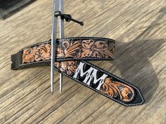 a pair of scissors sitting on top of a wooden table next to a leather belt