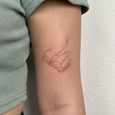 a woman's arm with a tattoo on it that has two hands holding an open book