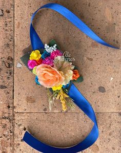 a bouquet of flowers on the ground with a blue ribbon around it that says i love you