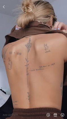 the back of a woman's body with tattoos on her upper and lower back