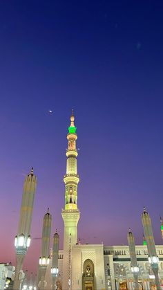 a tall white building with a green dome at night