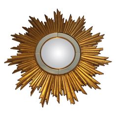 a gold sunburst mirror on a white wall