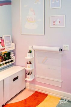 a child's room with pink walls and pictures on the wall