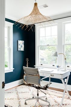 a home office with blue walls and white furniture