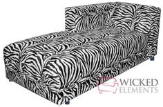 an animal print couch with black and white stripes on the back, in front of a white background