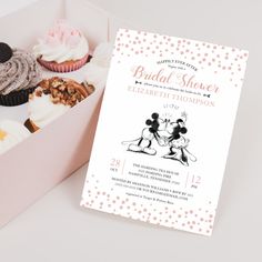 a box filled with lots of cupcakes next to a card