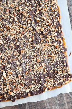 a square chocolate dessert with nuts on top