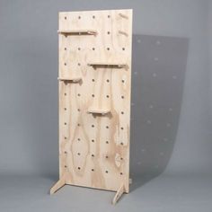 a wooden rack with pegs and holes on the front for storing items or tools