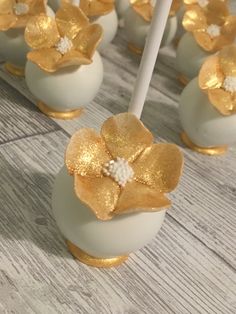 white and gold cake pops with flowers on them