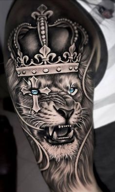 a man's arm with a lion wearing a crown on it and blue eyes