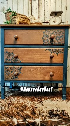 an old dresser is painted blue and brown with the words mandala on it